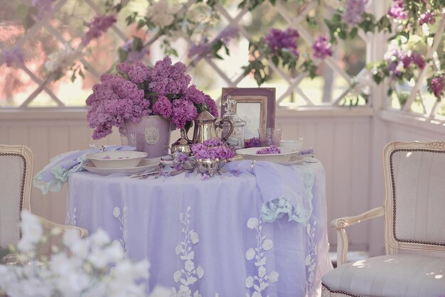 Uma mesa com uma toalha roxa e flores