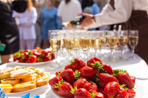 Uma mesa de banquete com taças de vinho e pratos com lanches