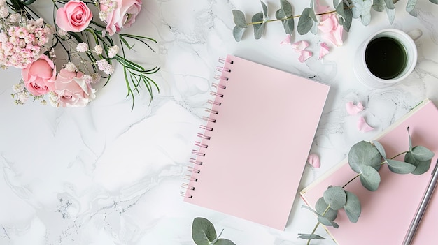 uma mesa de escritório organizada com um caderno de flores rosa delicadas refrescante ramo de eucalipto e papel rosa vazio oferecendo uma mistura perfeita de estilo e funcionalidade com amplo espaço de cópia