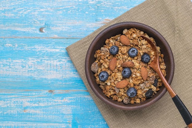 Uma mesa de madeira azul cheia de muesli com nozes e frutas. postura plana.