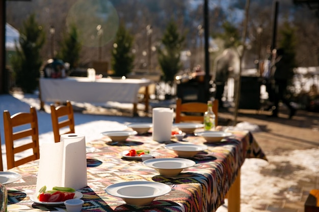 Uma mesa posta para convidados sob o céu aberto no inverno