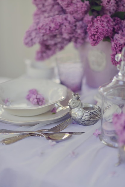 Uma mesa posta para um casamento com flores roxas na mesa.