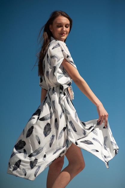 Uma modelo usa um vestido branco com penas.