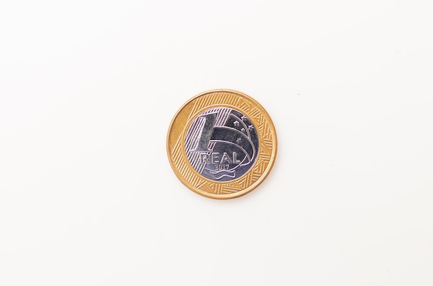 Foto uma moeda de 1 real isolada no fundo branco para o conceito de economia brasileira