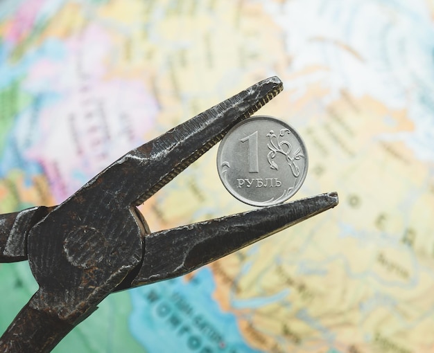 Uma moeda de rublo russo em um alicate velho o conceito de crise na Rússia e sanções contra a economia russa