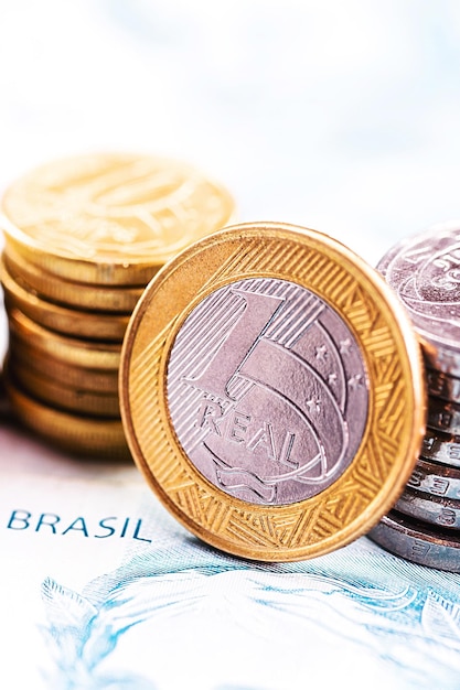 uma moeda real e barras de ouro Conceito de apreciação da moeda brasileira no mercado de ações