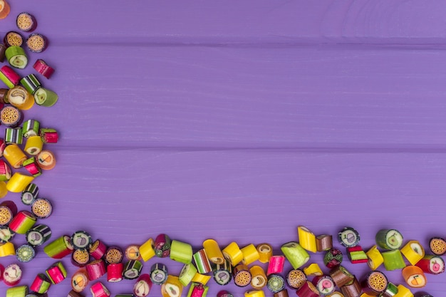 Foto uma moldura de canto feita de balas de caramelo coloridas