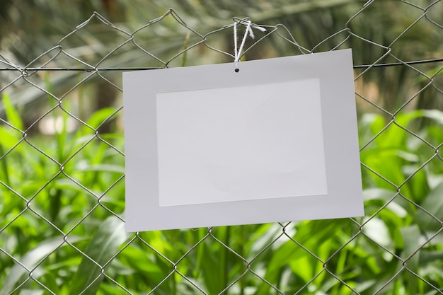 Uma moldura de papel pendurada em uma cerca de proteção de fazenda