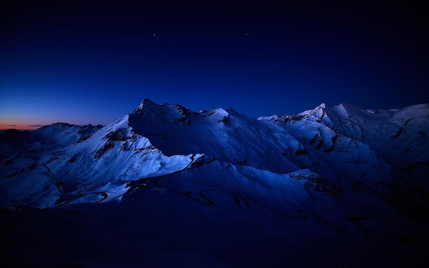 uma montanha coberta de neve com uma estrela no céu