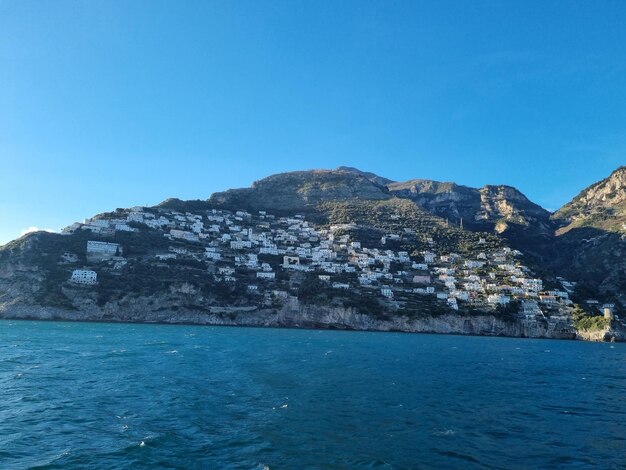 Foto uma montanha com casas no topo e um céu azul