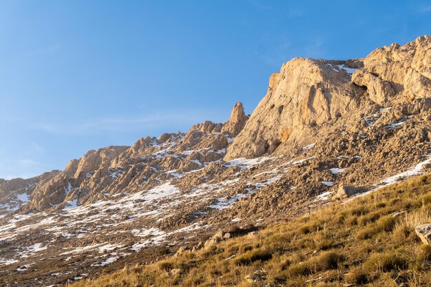 Foto uma montanha com neve no chão e um céu azul