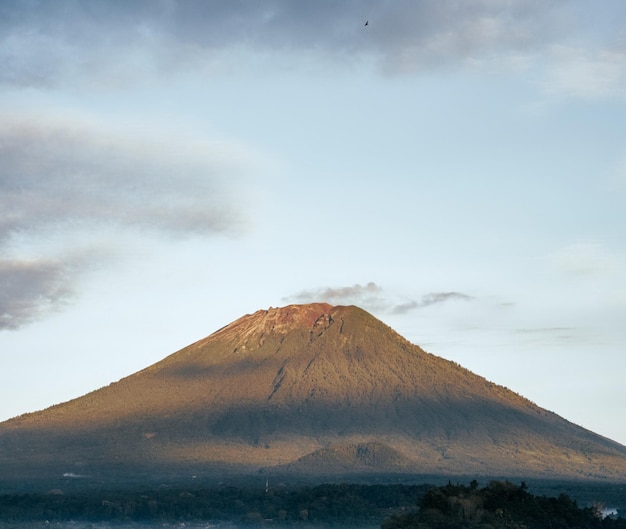 Foto uma montanha com um céu azul e algumas nuvens