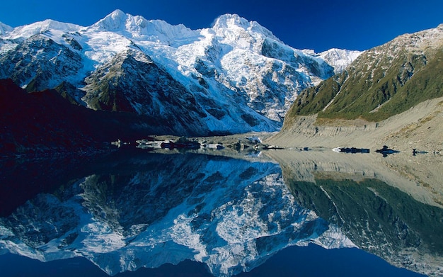 uma montanha é refletida na água com um céu azul