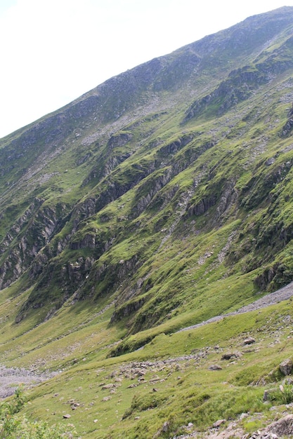 Uma montanha verde com pedras e grama