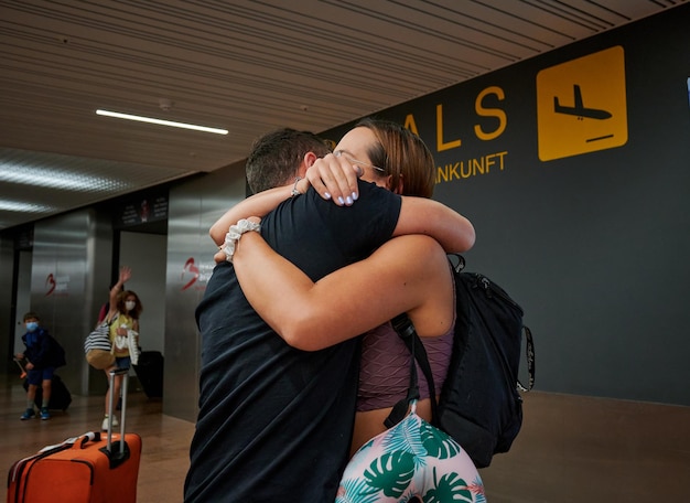 Foto uma mulher abraçando o homem após a chegada da viagem