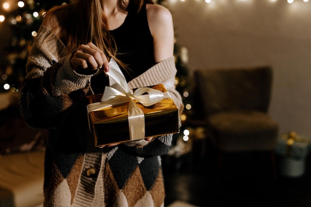 Uma mulher abre um close de mãos de presente de natal