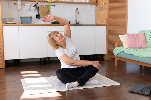 Uma mulher adulta pratica exercícios em casa