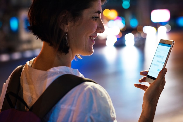 Uma mulher adulta usando o celular no período nocturno