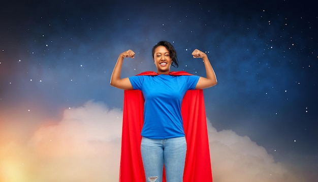 Foto uma mulher afro-americana feliz com uma capa vermelha de super-herói.