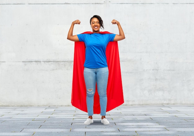 Foto uma mulher afro-americana feliz com uma capa vermelha de super-herói.