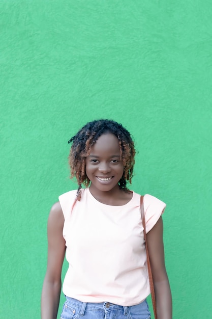 Uma mulher afro-americana sorridente em um fundo verde Retrato emoções positivas