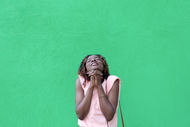 Uma mulher afro-americana sorridente feliz em um fundo verde Copie o espaço Emoções positivas