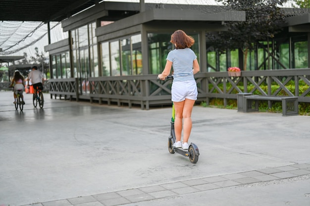 Uma mulher anda de scooter no aterro de Kazan Transporte ecológico