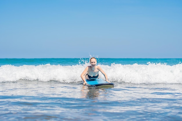 Uma mulher aprende a surfar na espuma. Bali, Indonésia