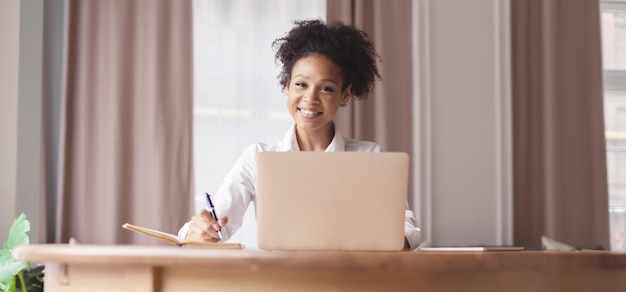 Uma mulher aprendendo online em casa usa um laptop