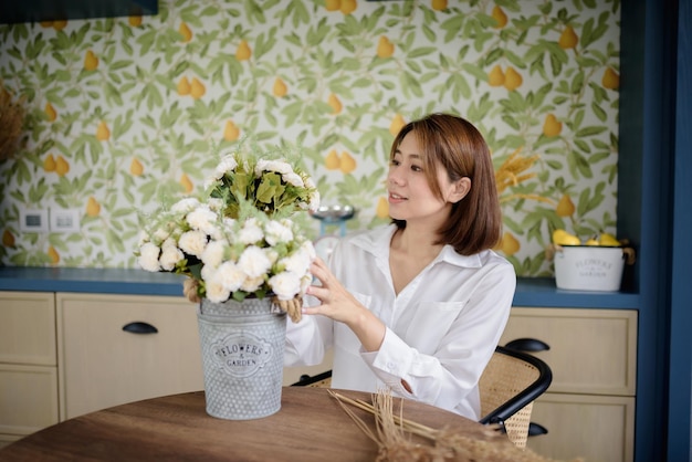 Uma mulher asiática está organizando flores