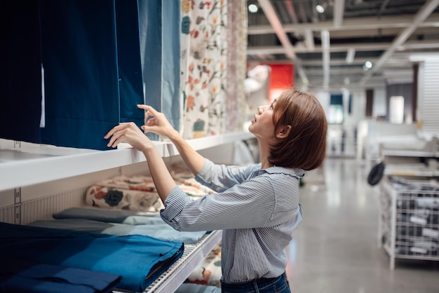 Uma mulher asiática está selecionando tecidos e têxteis no shopping