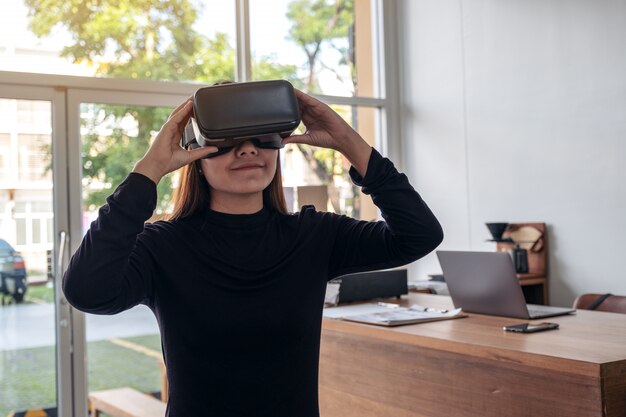 Uma mulher asiática usando uma câmera vr enquanto se diverte jogando