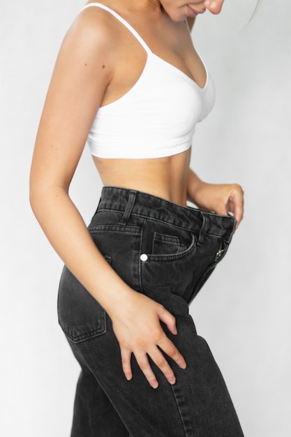 Foto uma mulher bonita de jeans mostra o quanto ela perdeu peso