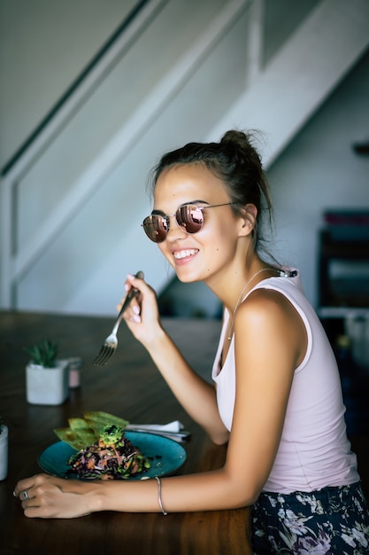 Foto uma mulher bonita tem café da manhã em um café elegante