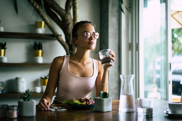 Foto uma mulher bonita tem café da manhã em um café elegante