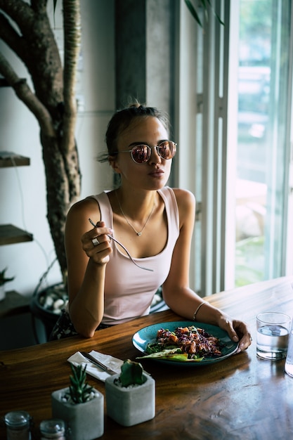 Uma mulher bonita tem café da manhã em um café elegante