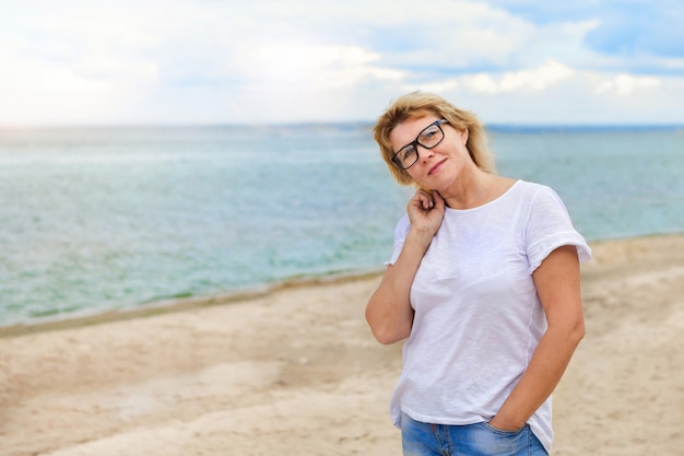 Uma mulher caminha ao ar livre à beira do rio da praia