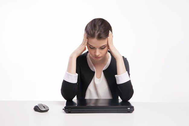 Uma mulher cansada na frente de um laptop, isolado no fundo branco