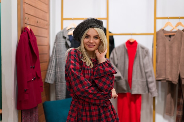 Foto uma mulher caucasiana em uma boutique de moda escolhe o vestido. um estilista profissional ajuda os clientes a escolher roupas. temporada de férias compras descontos venda shopping europeu menina andar. estilo de vida