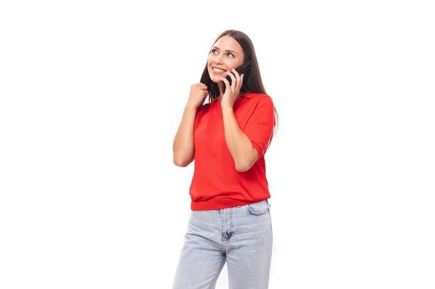 Uma mulher caucasiana sorridente de um ano de idade com cabelo escuro reto está vestida com uma camisa vermelha de mangas curtas