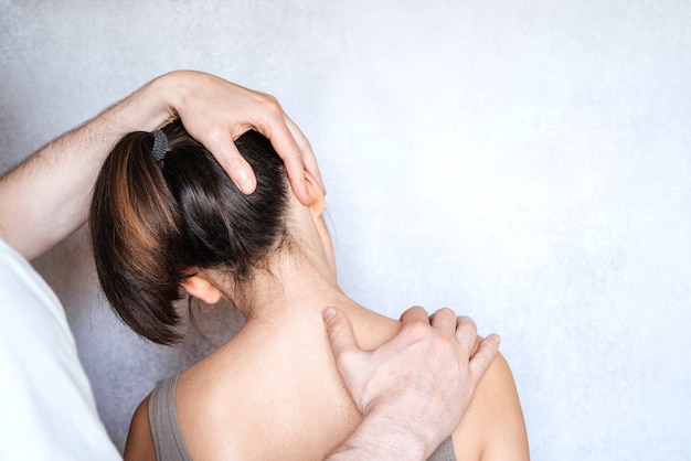 Uma mulher com ajuste de pescoço quiropraxia. osteopatia, cinesiologia, correção de má postura