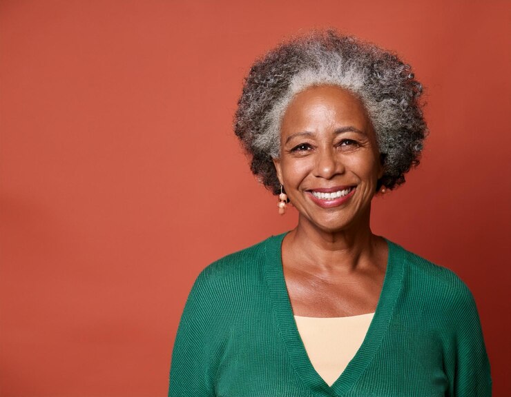 uma mulher com cabelo cinzento e uma camisa verde com um suéter verde