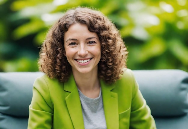 uma mulher com cabelo encaracolado e uma jaqueta verde sorri para uma foto