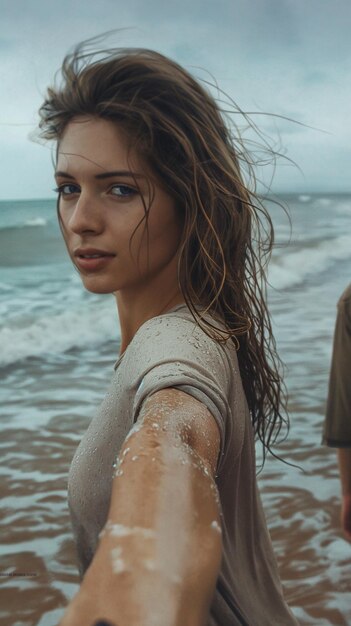 Foto uma mulher com o cabelo molhado está de pé na praia com o oceano ao fundo