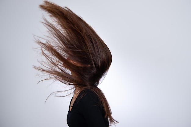 Uma mulher com penteado moderno está brincando com seu cabelo comprido