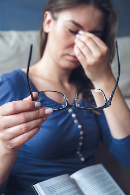 Uma mulher com problemas de visão está lendo um livro de óculos