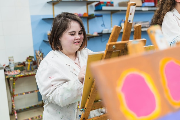 Uma mulher com síndrome de Down concentra-se em sua pintura