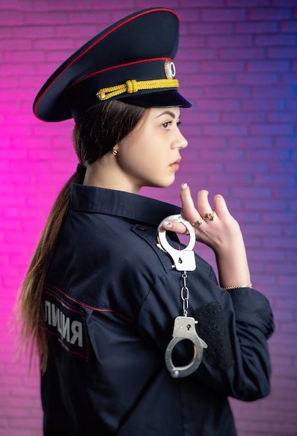 Foto uma mulher com um uniforme de policial russo com algemas tradução para o inglês polícia