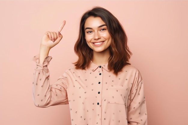 Uma mulher com uma camisa rosa apontando para cima com o dedo indicador