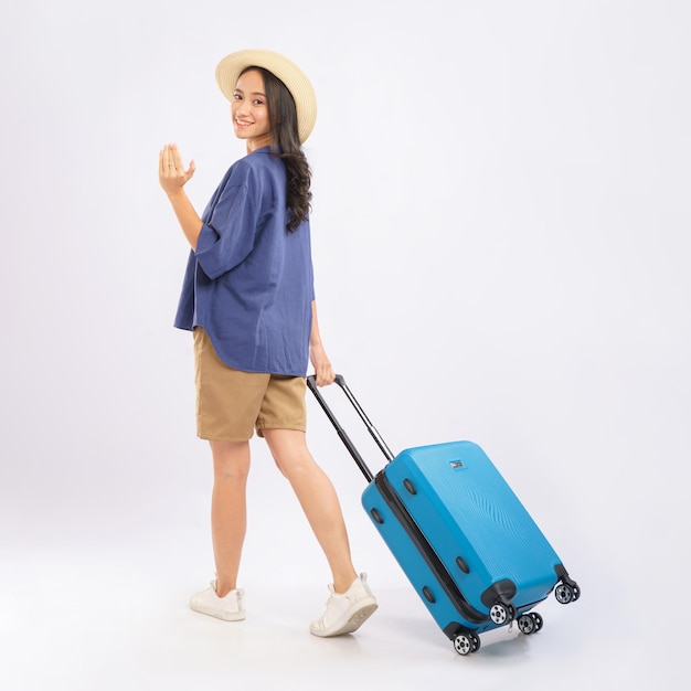 Uma mulher com uma mala azul caminha e carrega uma mala azul.